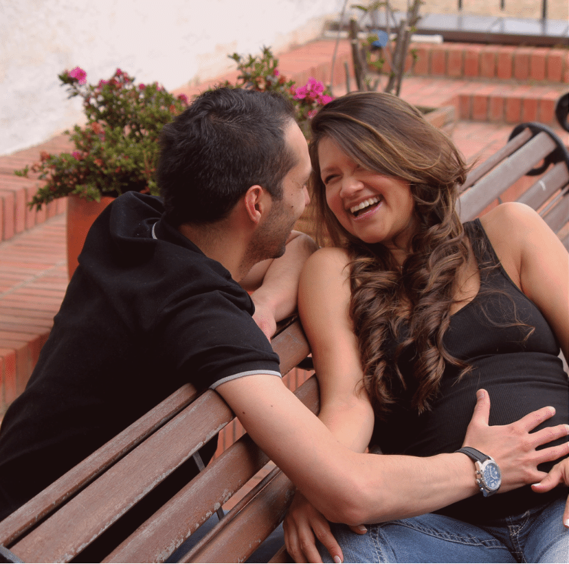 A happy pregnant woman and her partner smiling