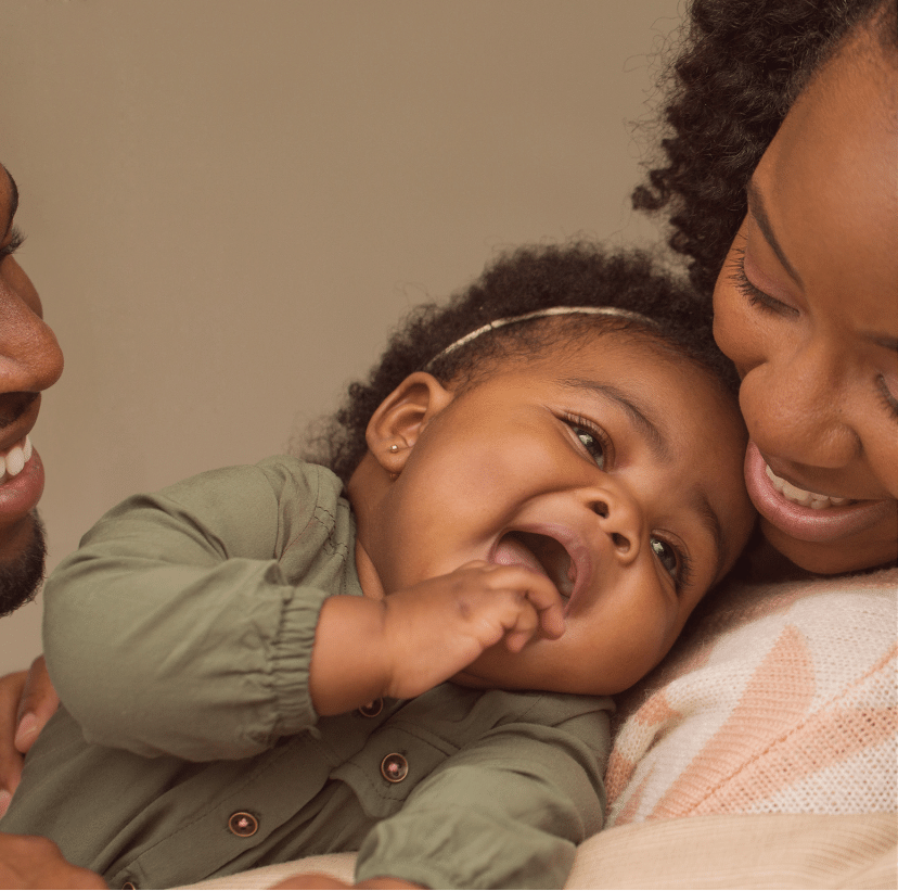 A happy mother with her new born and partner all smiling